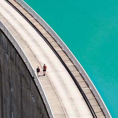 people walking on edge of hydrogen dam